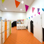Widok na kolorowy korytarz z szafkami dla dzieci w prywatnym żłobku, przedszkolu i klubie dziecięcym.