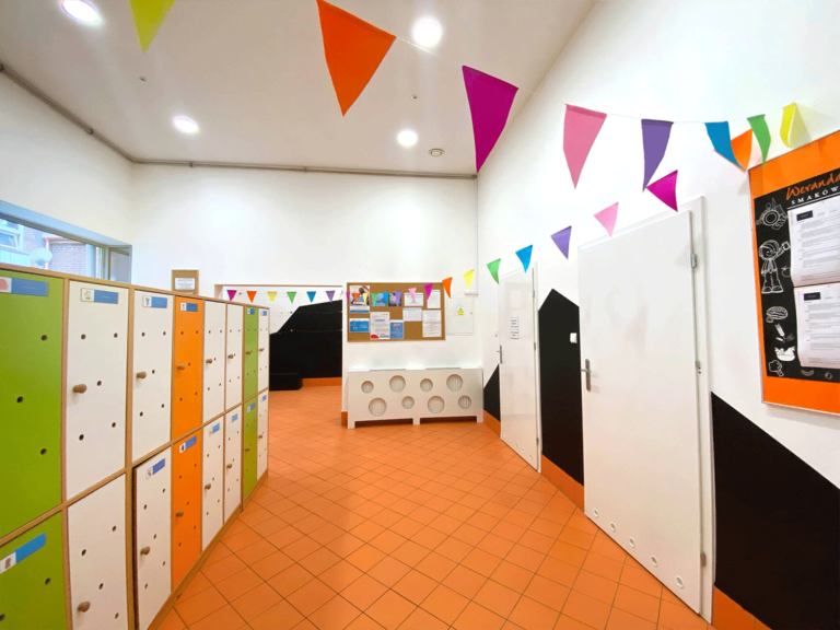 Widok na kolorowy korytarz z szafkami dla dzieci w prywatnym żłobku, przedszkolu i klubie dziecięcym.