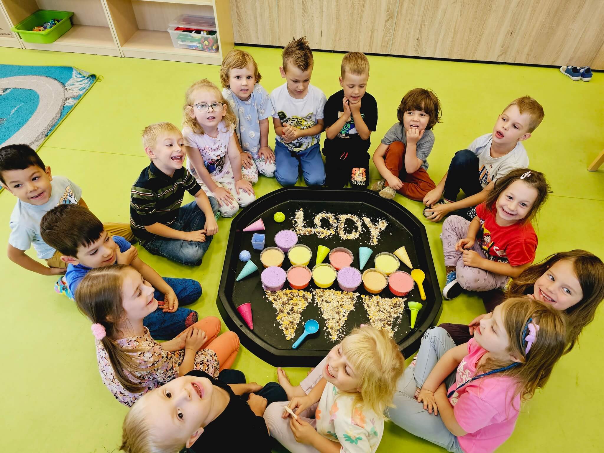 Grupa dzieci w przedszkolu na zajęciach sensorycznych.