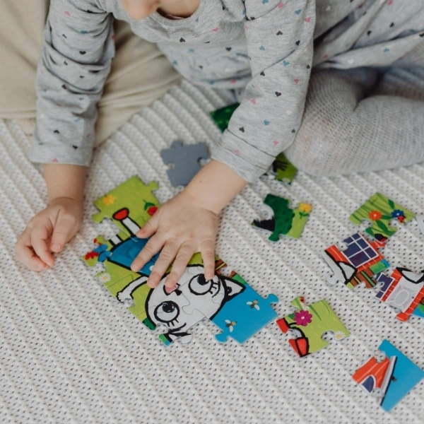 Małe dziecko układa puzzle Kicia Kocia